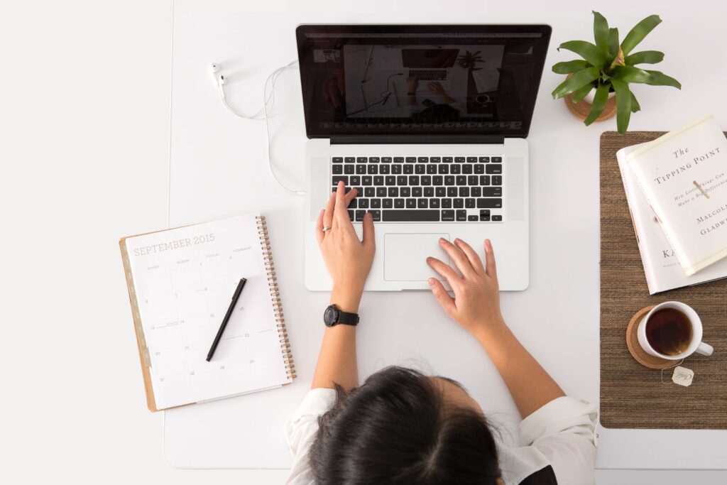 A Person Sitting Infront of a Laptop Working