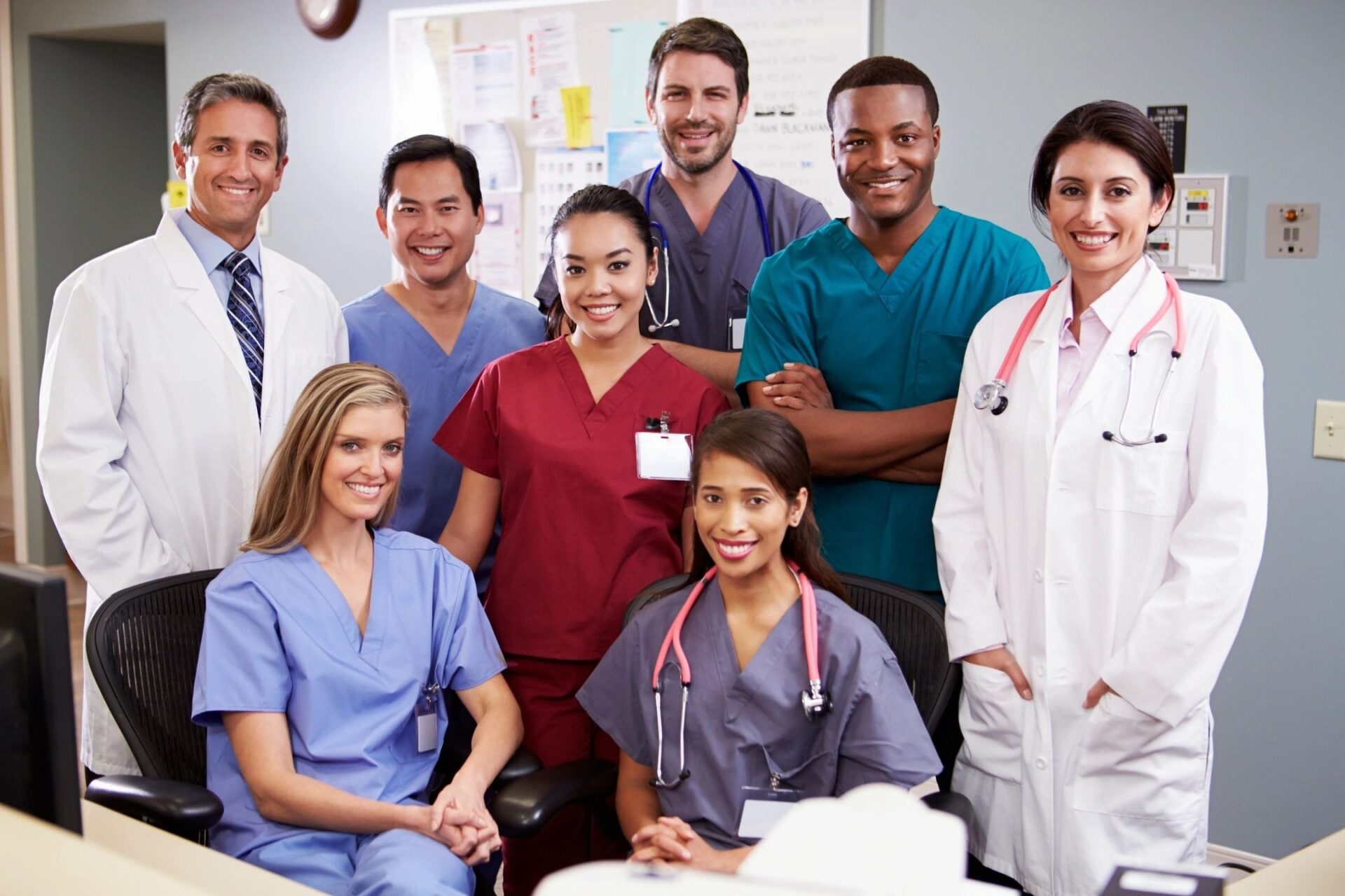 Portrait of medical team at nurses station smiling at camera